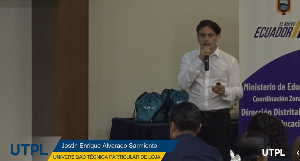 Jostin Alvarado exponiendo con micrófono en una ponencia de la UTPL